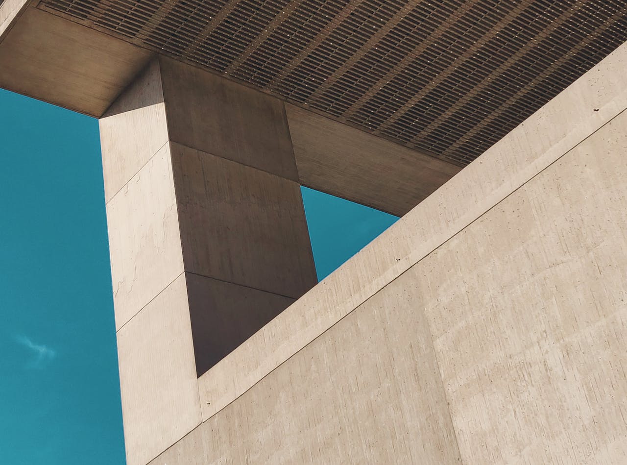 A striking view of contemporary architecture showcasing concrete geometry against a clear blue sky.